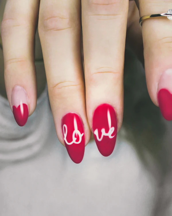 ציפורניים בגוון בורדו עם המילה love בכתב יד